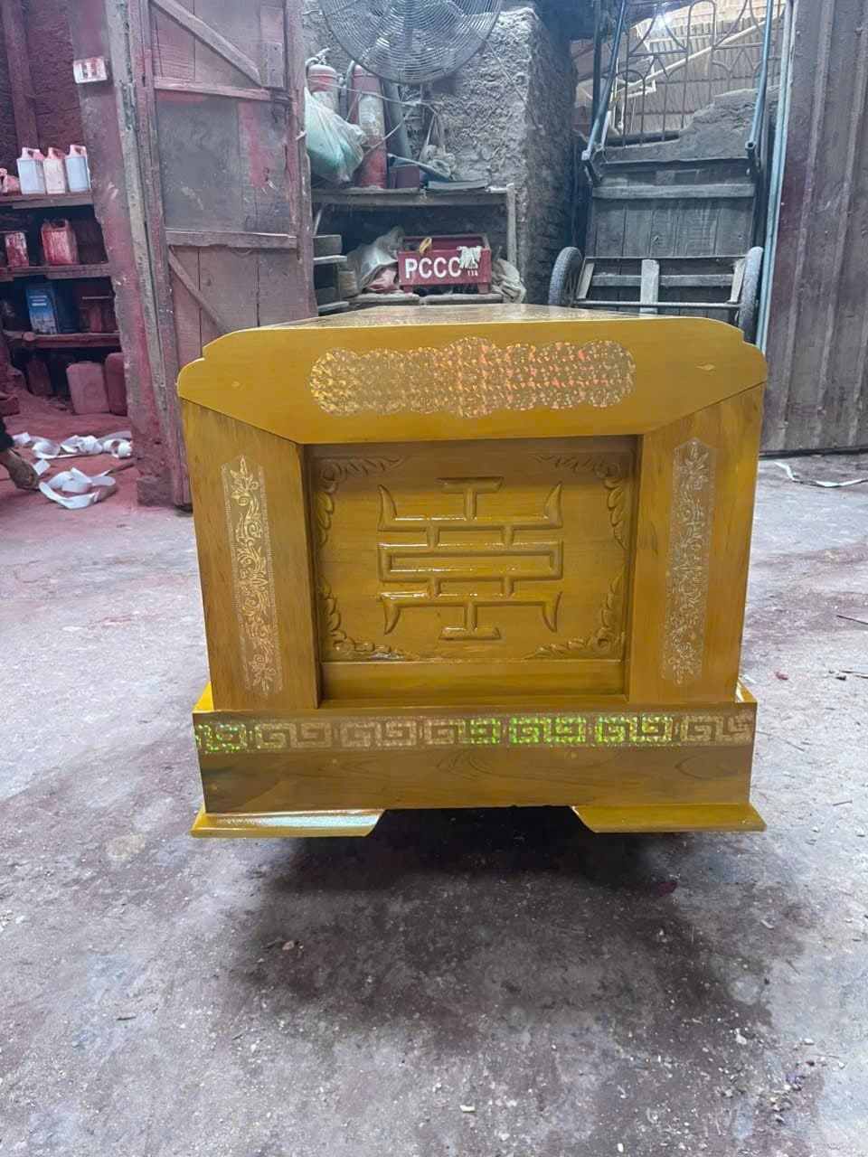 Đầu quan tài gỗ vàng tâm chạm chữ Thọ kiểu vuông nét gấp khúc, chân quan viền hồi văn