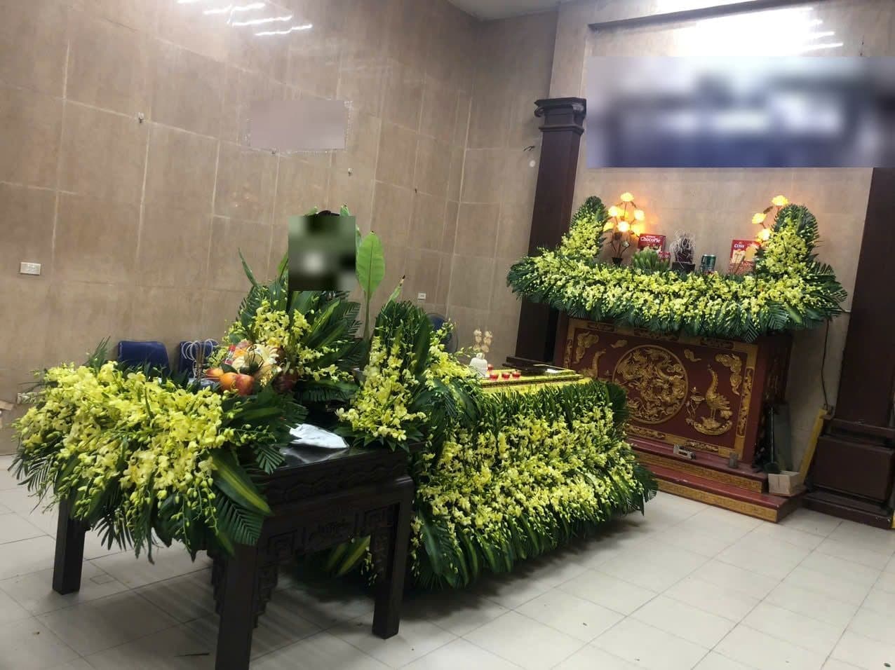 Linh cữu phủ hoa lan vàng và hương án bài trí song song trong phòng lễ