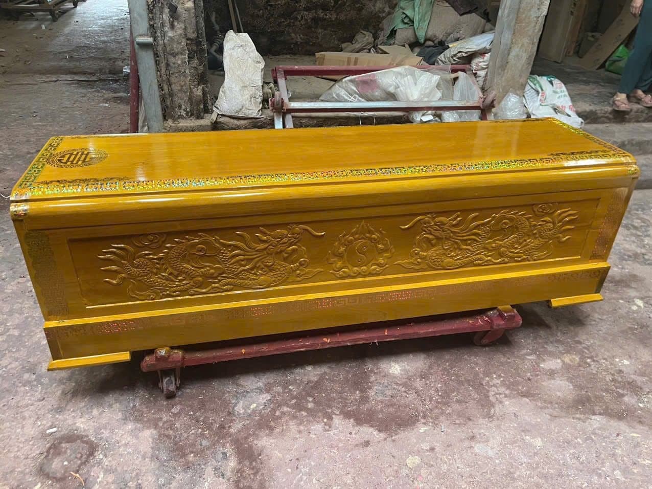 Quan tài gỗ vàng tâm sơn cánh gián chạm lưỡng long, viền hồi văn chạy quanh chân quan
